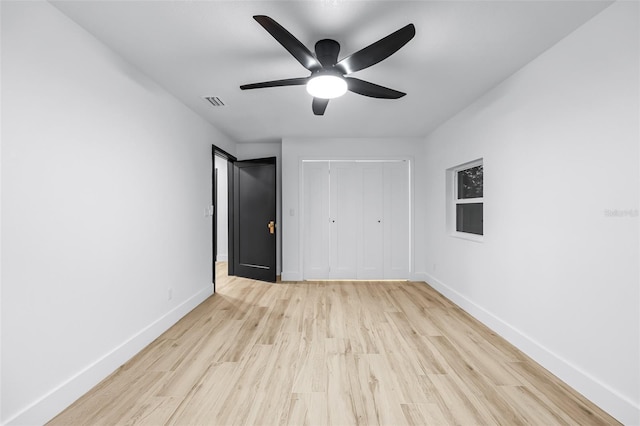 unfurnished bedroom featuring light wood-type flooring, a closet, and ceiling fan