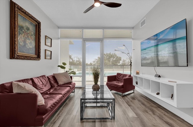 living room featuring ceiling fan, floor to ceiling windows, and wood-type flooring