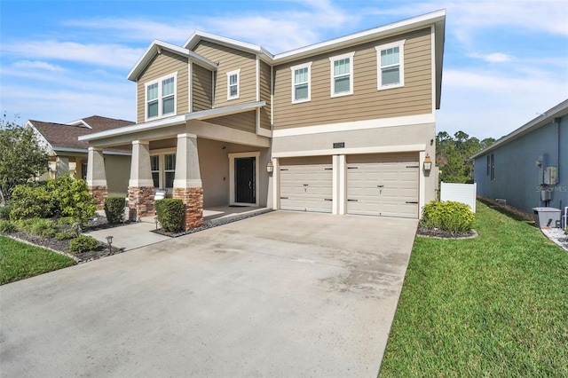 craftsman inspired home with driveway, a front yard, an attached garage, and stucco siding