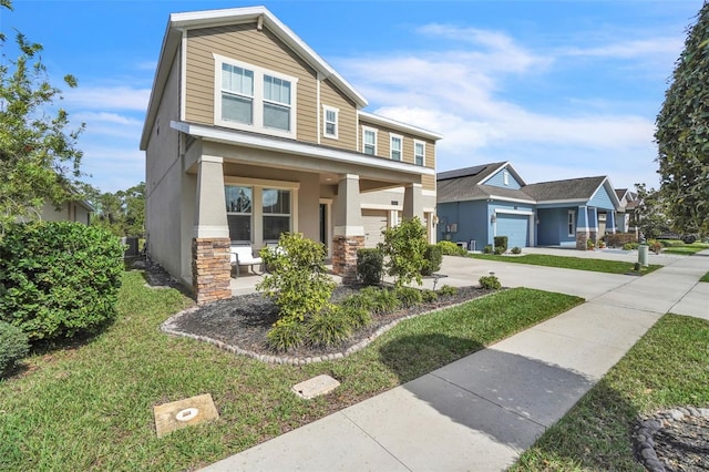 view of front of home with covered porch, a garage, stone siding, stucco siding, and a front lawn