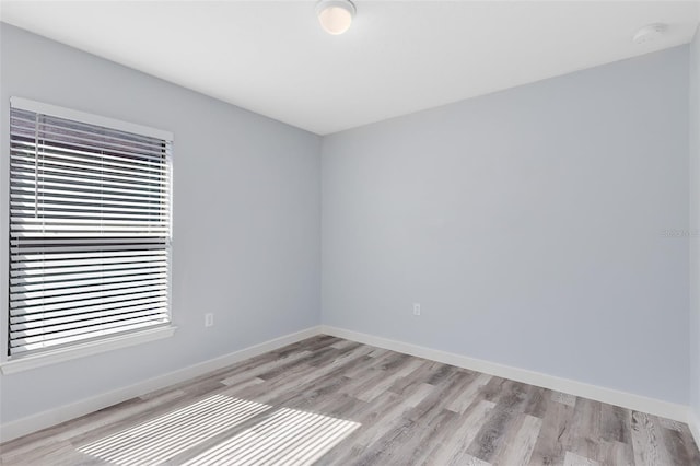 spare room featuring light wood-type flooring and plenty of natural light