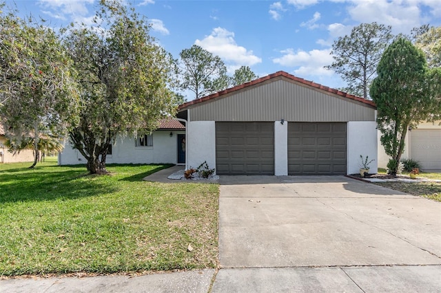 view of front of property featuring stucco siding, a front yard, a garage, driveway, and a tiled roof