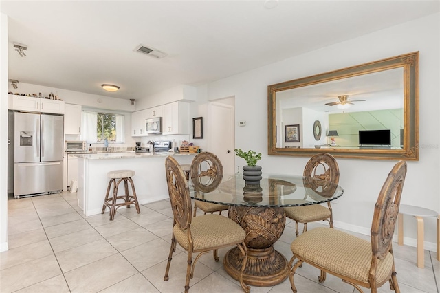 dining space with light tile patterned floors, a toaster, visible vents, and baseboards