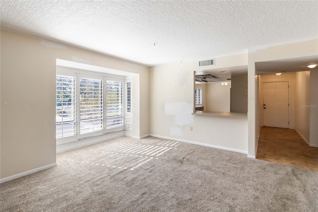unfurnished living room with carpet and a textured ceiling