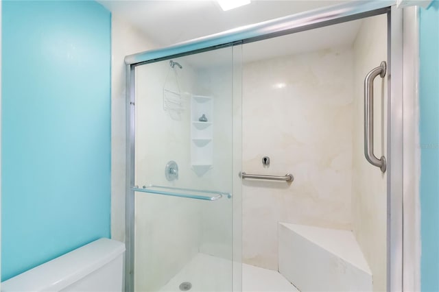 bathroom with toilet and a shower with shower door