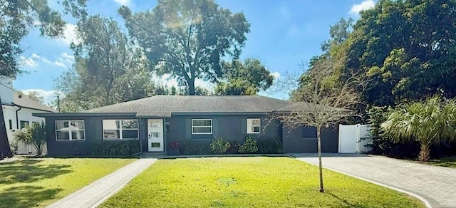 ranch-style house with driveway, stucco siding, and a front yard