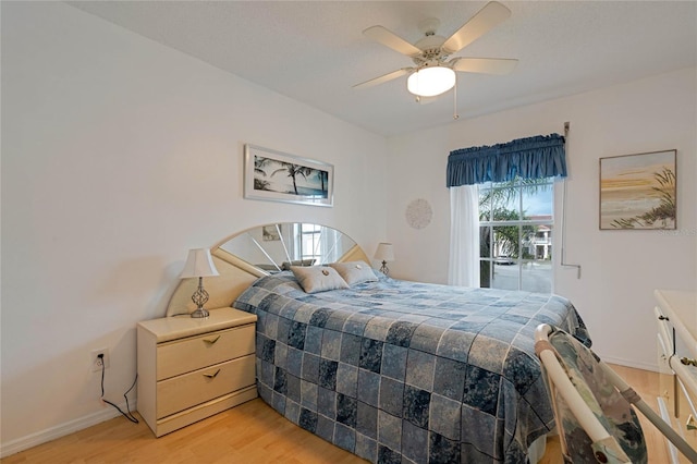 bedroom with a ceiling fan, baseboards, multiple windows, and light wood finished floors