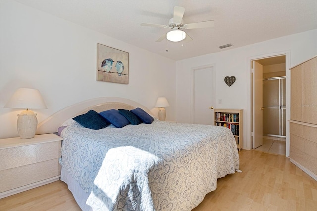 bedroom featuring a ceiling fan, visible vents, and light wood-style flooring