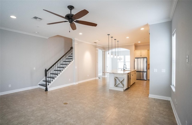 kitchen featuring open shelves, visible vents, freestanding refrigerator, a kitchen island with sink, and a sink