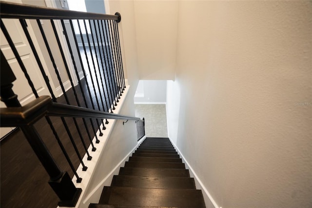 stairway featuring baseboards and wood finished floors