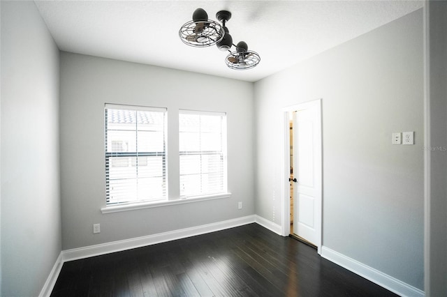 unfurnished room with dark wood-style floors and baseboards