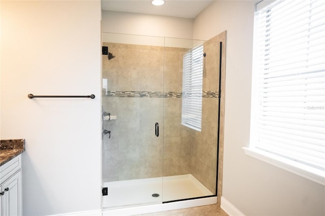 bathroom featuring a shower stall, vanity, and baseboards