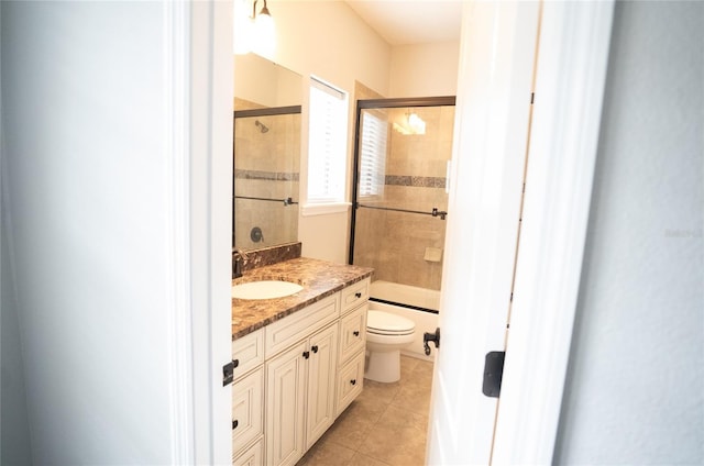 full bath featuring toilet, tile patterned flooring, bath / shower combo with glass door, and vanity