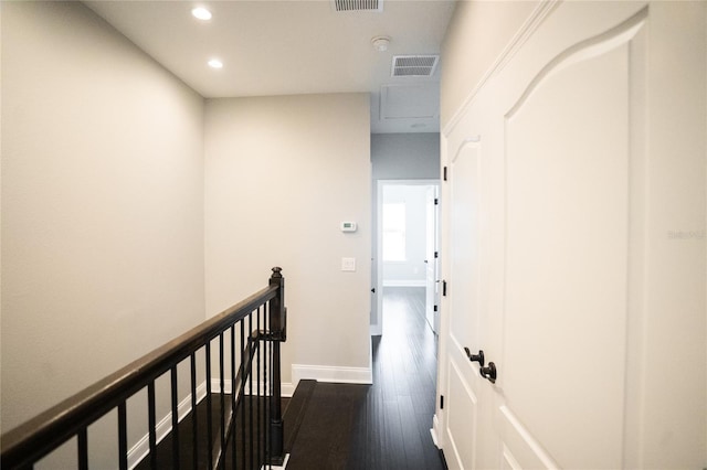 hall featuring visible vents, baseboards, dark wood-style floors, an upstairs landing, and recessed lighting