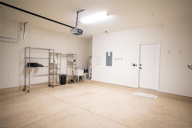 garage with concrete block wall, electric panel, baseboards, and a garage door opener