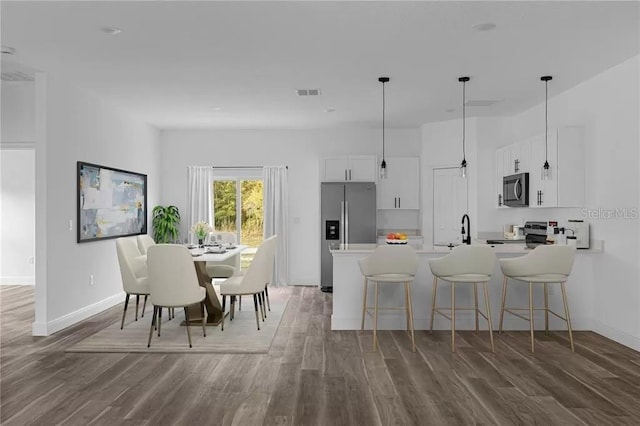 dining area featuring baseboards, visible vents, and dark wood finished floors