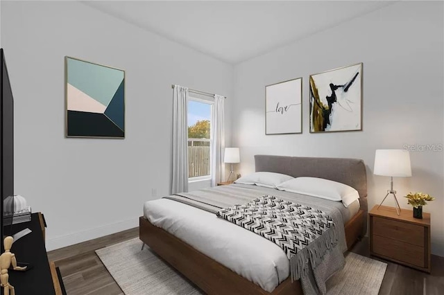 bedroom featuring wood finished floors and baseboards