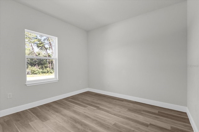 unfurnished room featuring baseboards and wood finished floors