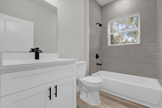 bathroom featuring vanity, bathing tub / shower combination, wood finished floors, and toilet