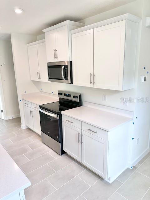 3219 Cup Dr, Lakeland, FL 33803 - kitchen featuring stainless steel appliances, white cabinets, light countertops, and recessed lighting