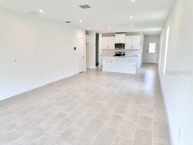 3219 Cup Dr, Lakeland, FL 33803 - unfurnished living room with recessed lighting and baseboards