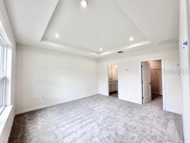 3219 Cup Dr, Lakeland, FL 33803 - unfurnished bedroom with carpet floors, a raised ceiling, recessed lighting, baseboards, and a walk in closet
