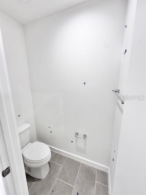 3219 Cup Dr, Lakeland, FL 33803 - bathroom with toilet, baseboards, and tile patterned floors