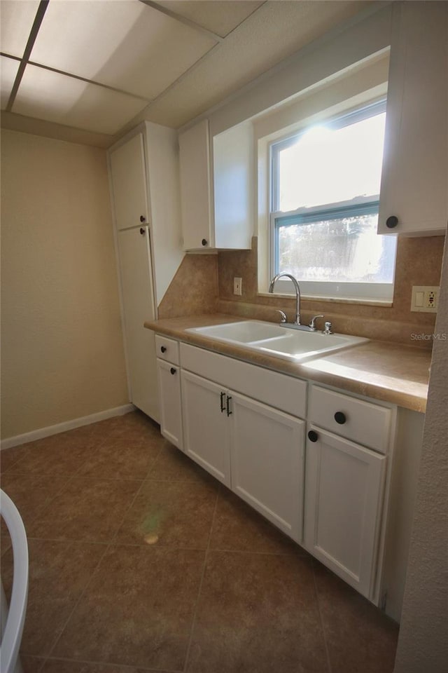6026 22nd Ave N Unit 4, Saint Petersburg, FL 33710 - kitchen featuring sink, dark tile patterned flooring, white cabinets, and backsplash