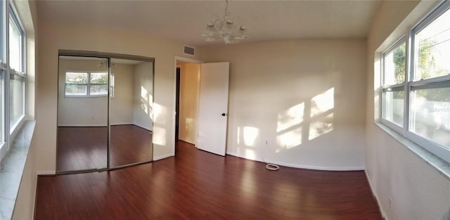 6026 22nd Ave N Unit 4, Saint Petersburg, FL 33710 - unfurnished bedroom featuring an inviting chandelier, dark hardwood / wood-style flooring, and a closet