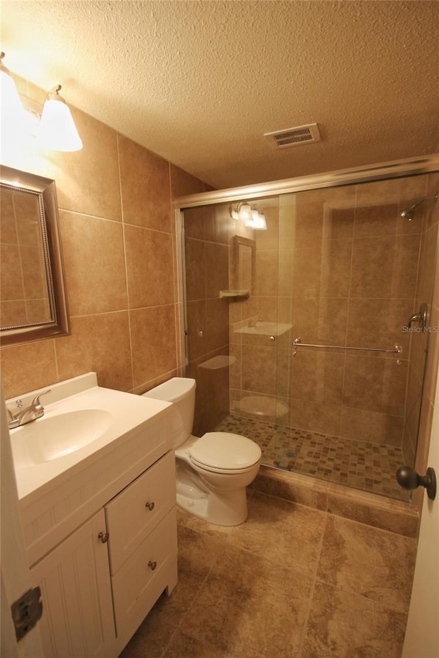 6026 22nd Ave N Unit 4, Saint Petersburg, FL 33710 - bathroom with a shower with door, toilet, tile walls, a textured ceiling, and vanity