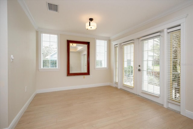 spare room featuring french doors, light wood-type flooring, visible vents, and crown molding