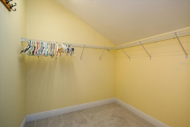 walk in closet featuring carpet floors and lofted ceiling