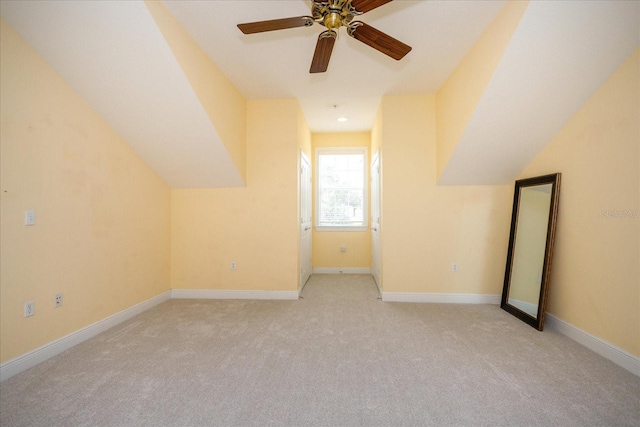 bonus room featuring lofted ceiling, light colored carpet, ceiling fan, and baseboards