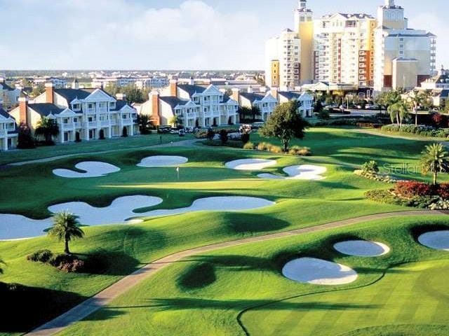 view of home's community featuring view of golf course and a yard