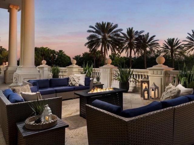 patio terrace at dusk with an outdoor living space with a fire pit