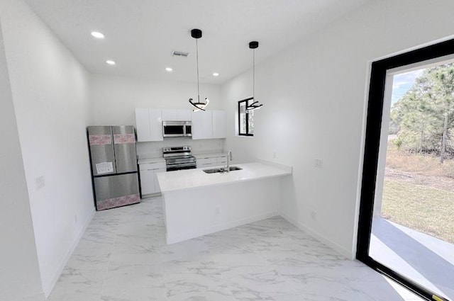 kitchen featuring sink, stainless steel appliances, kitchen peninsula, white cabinets, and hanging light fixtures