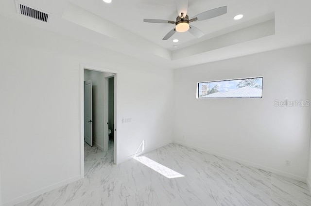 unfurnished room featuring a tray ceiling and ceiling fan