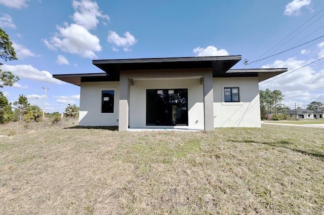 back of house with a lawn