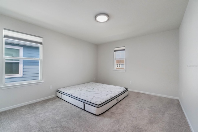 unfurnished bedroom with baseboards and light colored carpet