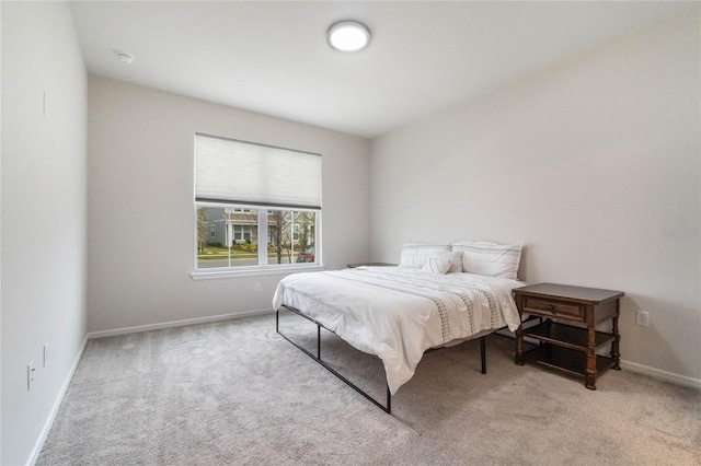 bedroom with light carpet and baseboards