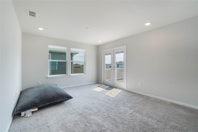 carpeted spare room featuring recessed lighting, visible vents, baseboards, and french doors