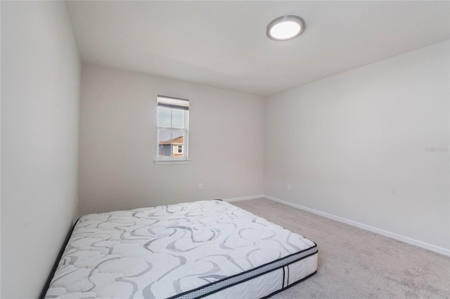 bedroom featuring light carpet and baseboards