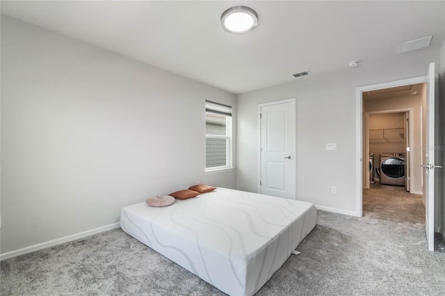 bedroom featuring light carpet, visible vents, washer and clothes dryer, and baseboards