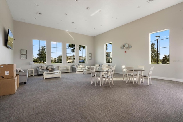 dining area featuring a wealth of natural light, visible vents, and dark carpet