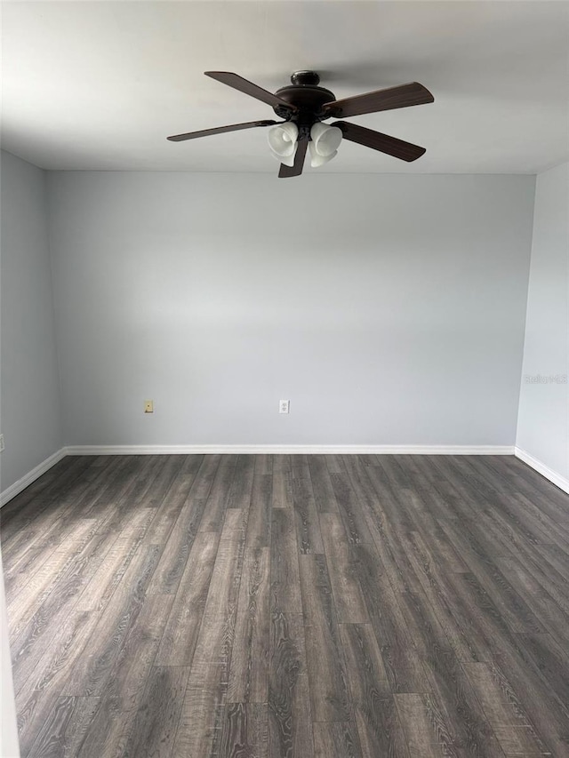 unfurnished room featuring baseboards and dark wood finished floors