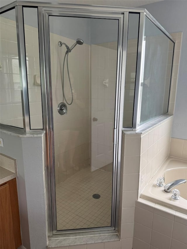 bathroom featuring a garden tub and a shower stall