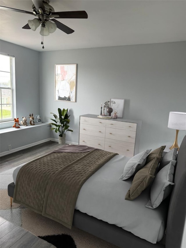 bedroom featuring ceiling fan, wood finished floors, and baseboards