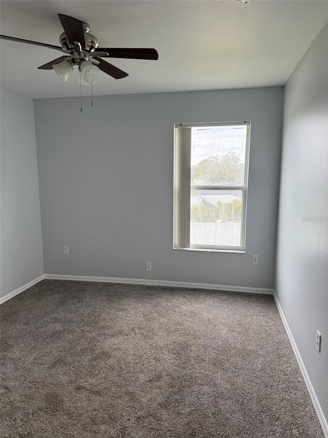 unfurnished room featuring a ceiling fan, carpet flooring, and baseboards