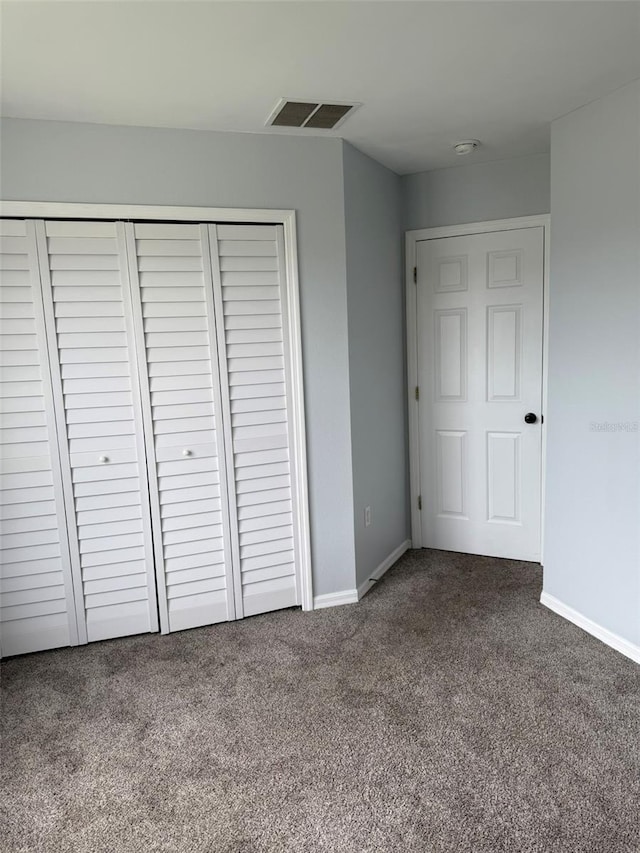 unfurnished bedroom with carpet floors, a closet, visible vents, and baseboards