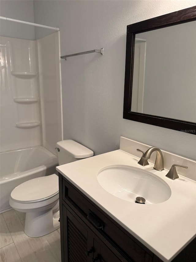 full bath featuring tub / shower combination, a textured wall, vanity, and toilet